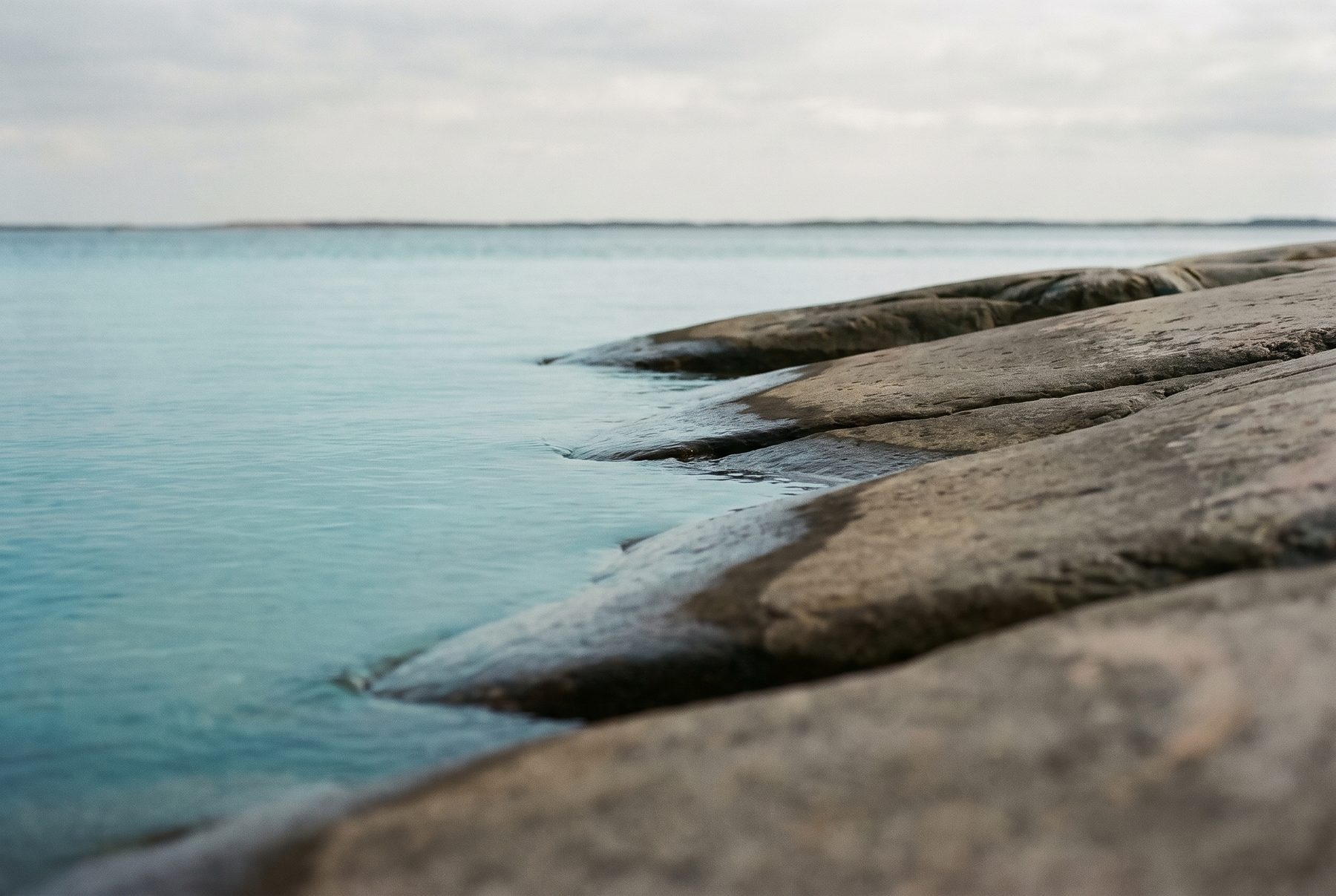 Gladde granietplaten van de Zweedse scherenkust bij kraakhelder water